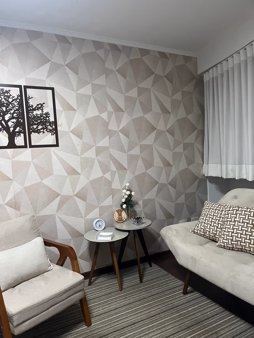 Poltronas diante da parede geométrica