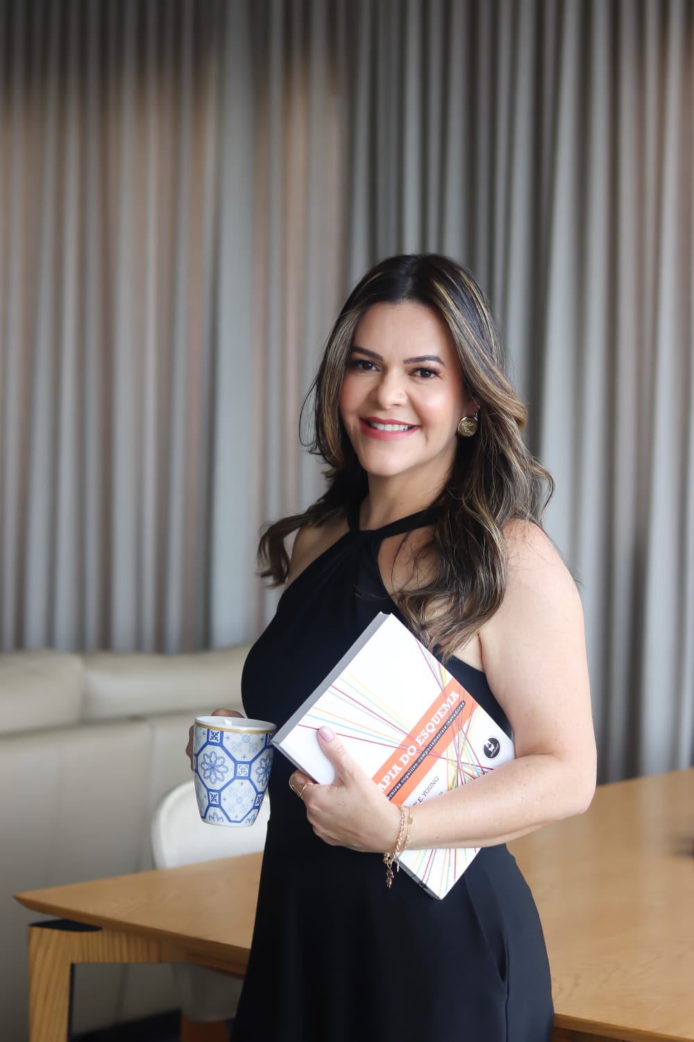 Almira Marques com uma caneca e um livro